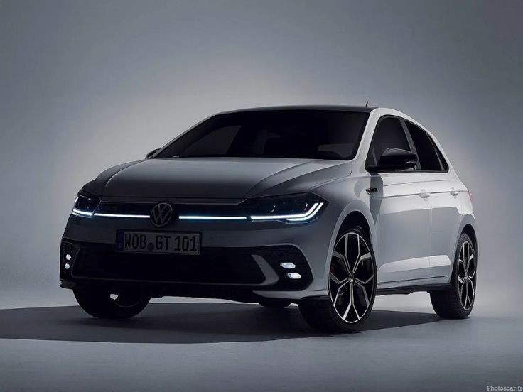 Modern white hatchback car with sleek LED headlights and sporty design displayed in a studio setting.