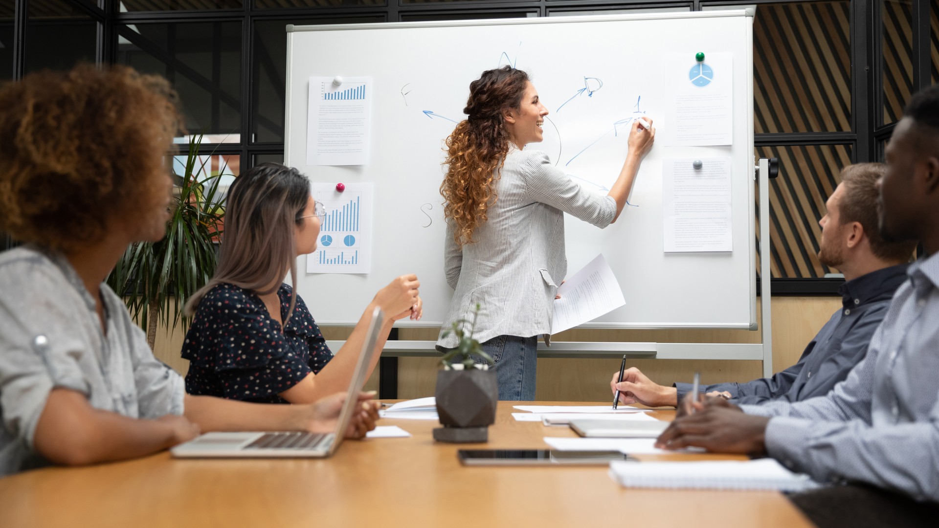 L’entraîneur féminin écrivent à bord faisant la présentation pour des employés